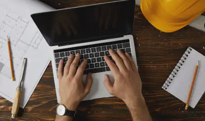 cropped image of architect typing on laptop at tab